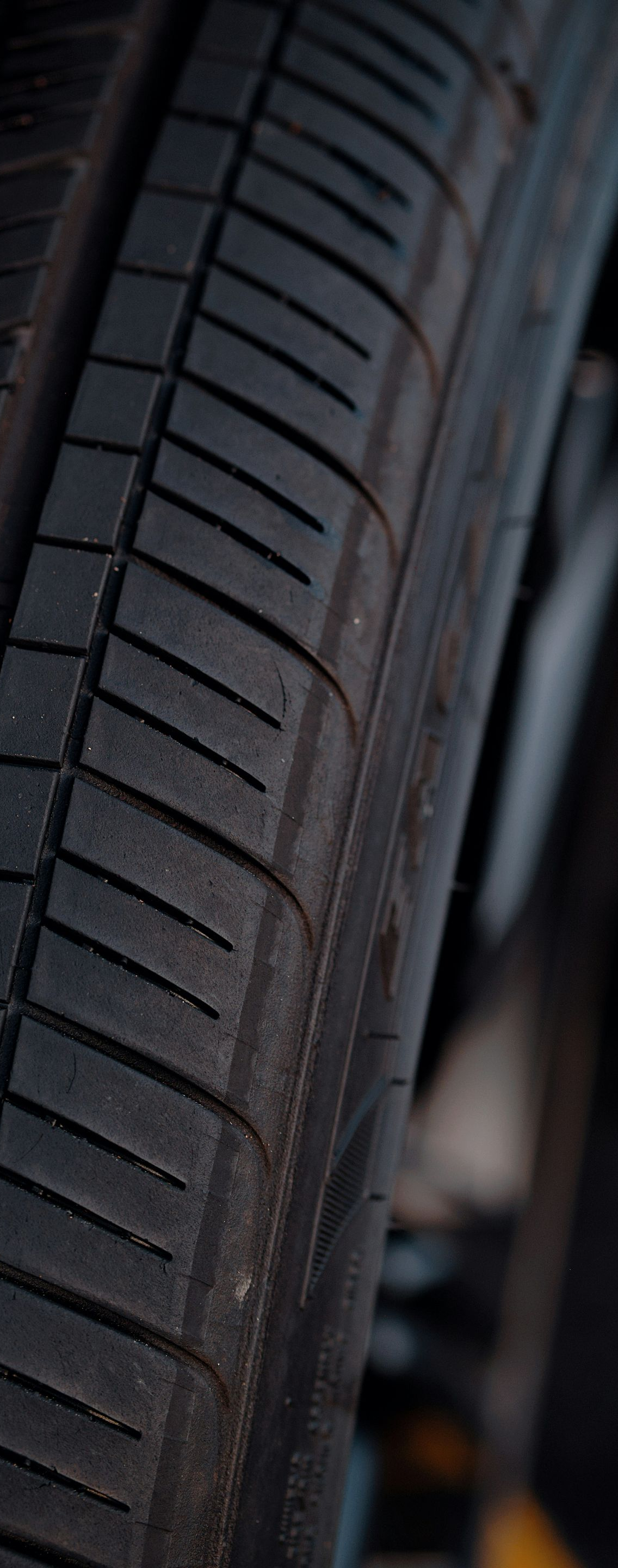 Close-up of a car tire tread and sidewall in dim lighting