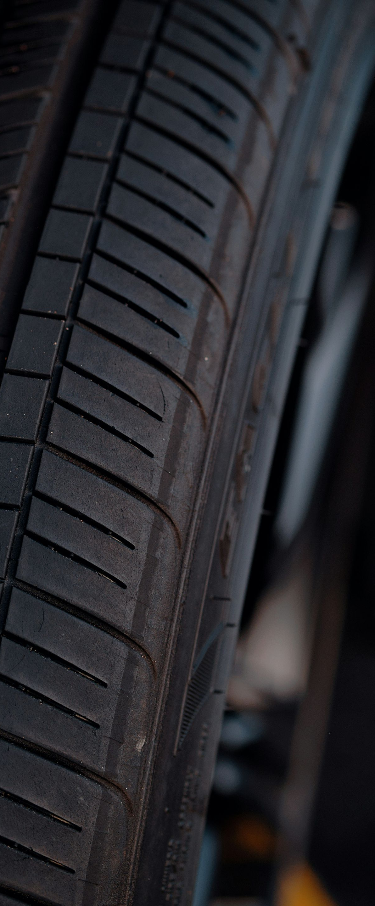 Close-up of a car tire tread and sidewall in dim lighting