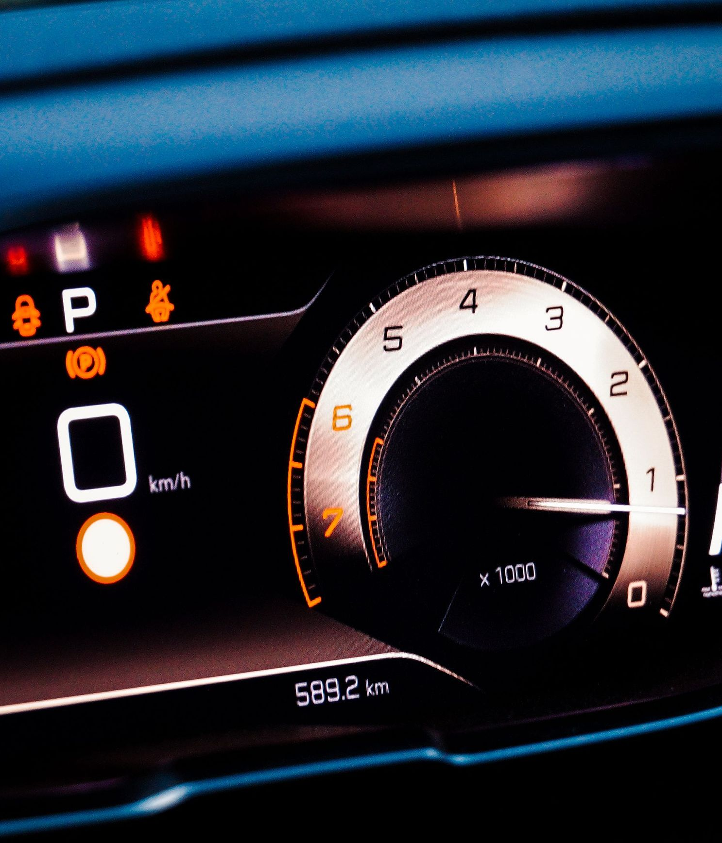 Car dashboard at night showing speedometer, warning lights, and gear in park, with 59,212 km on odometer