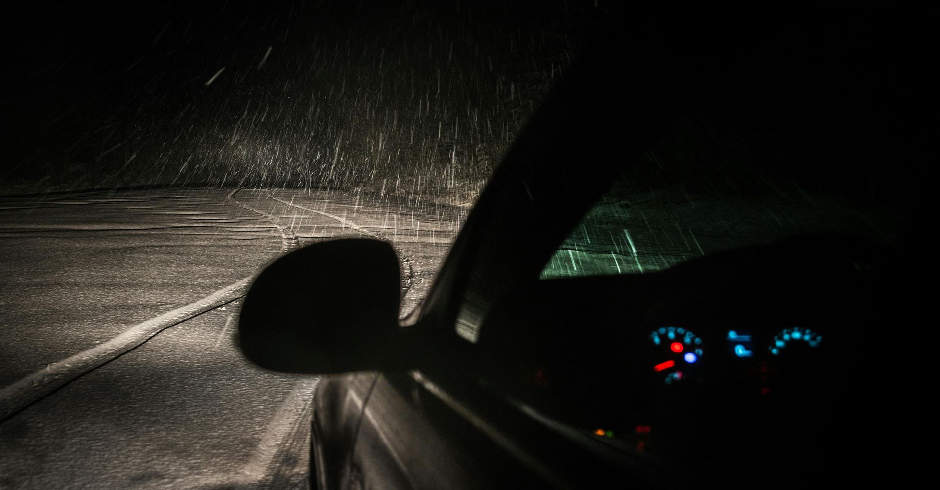 Car driving at night in heavy snow.