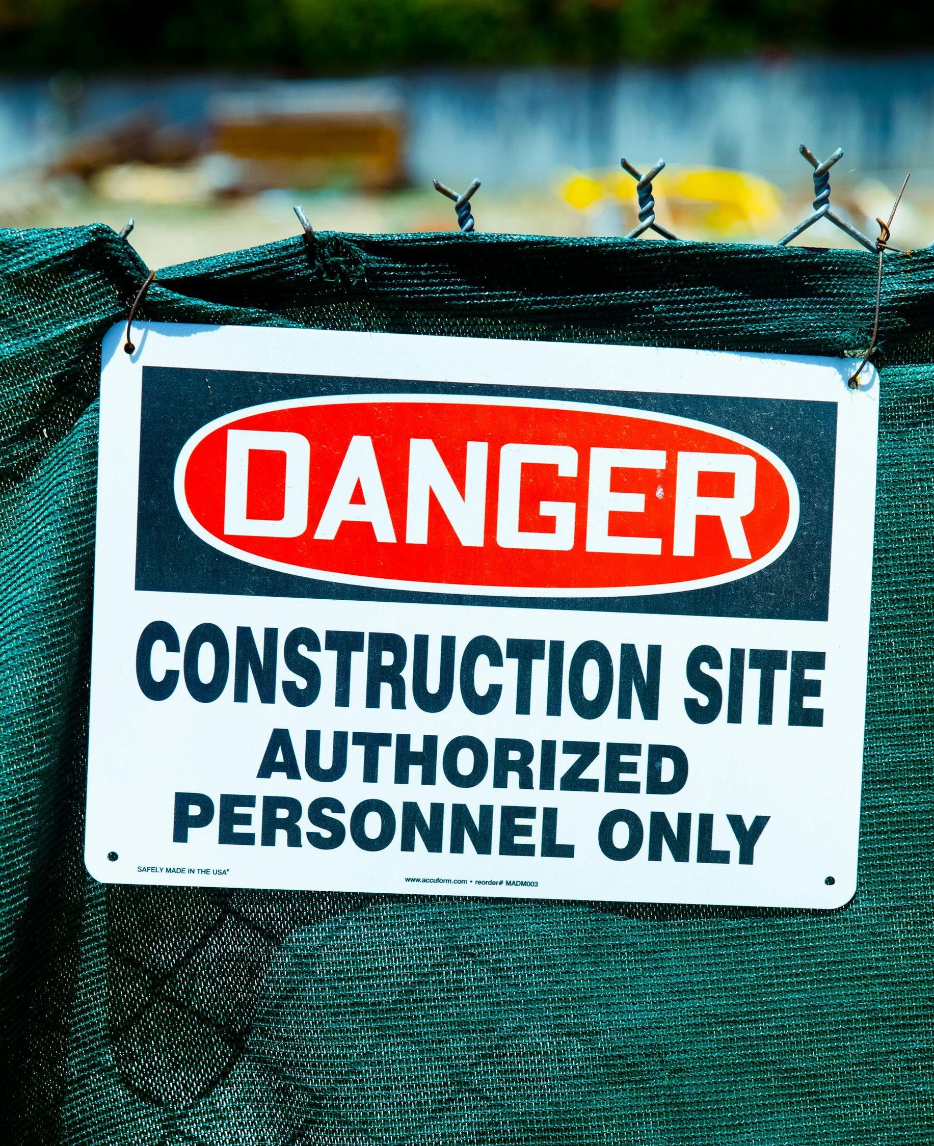 Danger sign on green fence: Construction site, authorized personnel only