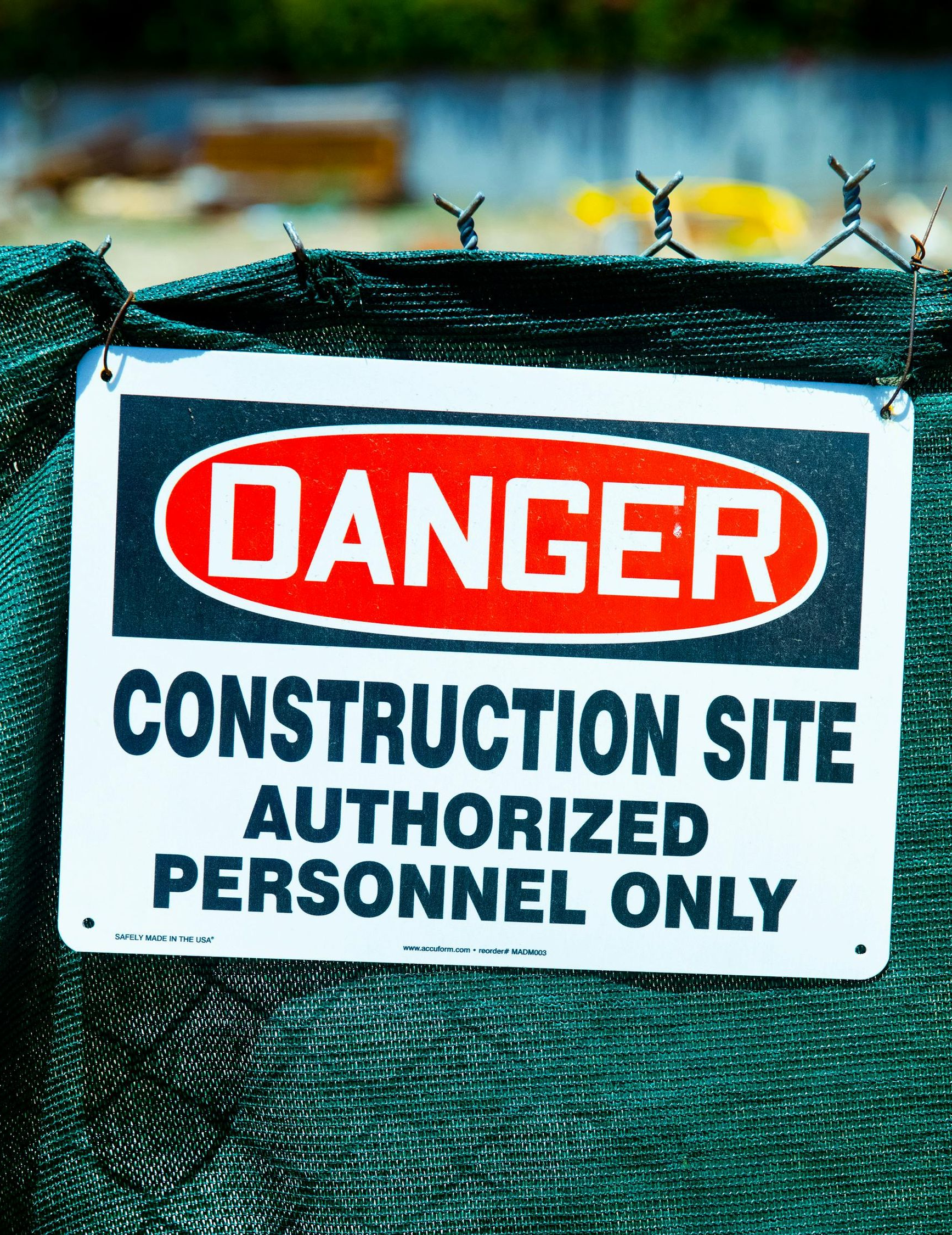 Danger sign on green fence: Construction site, authorized personnel only