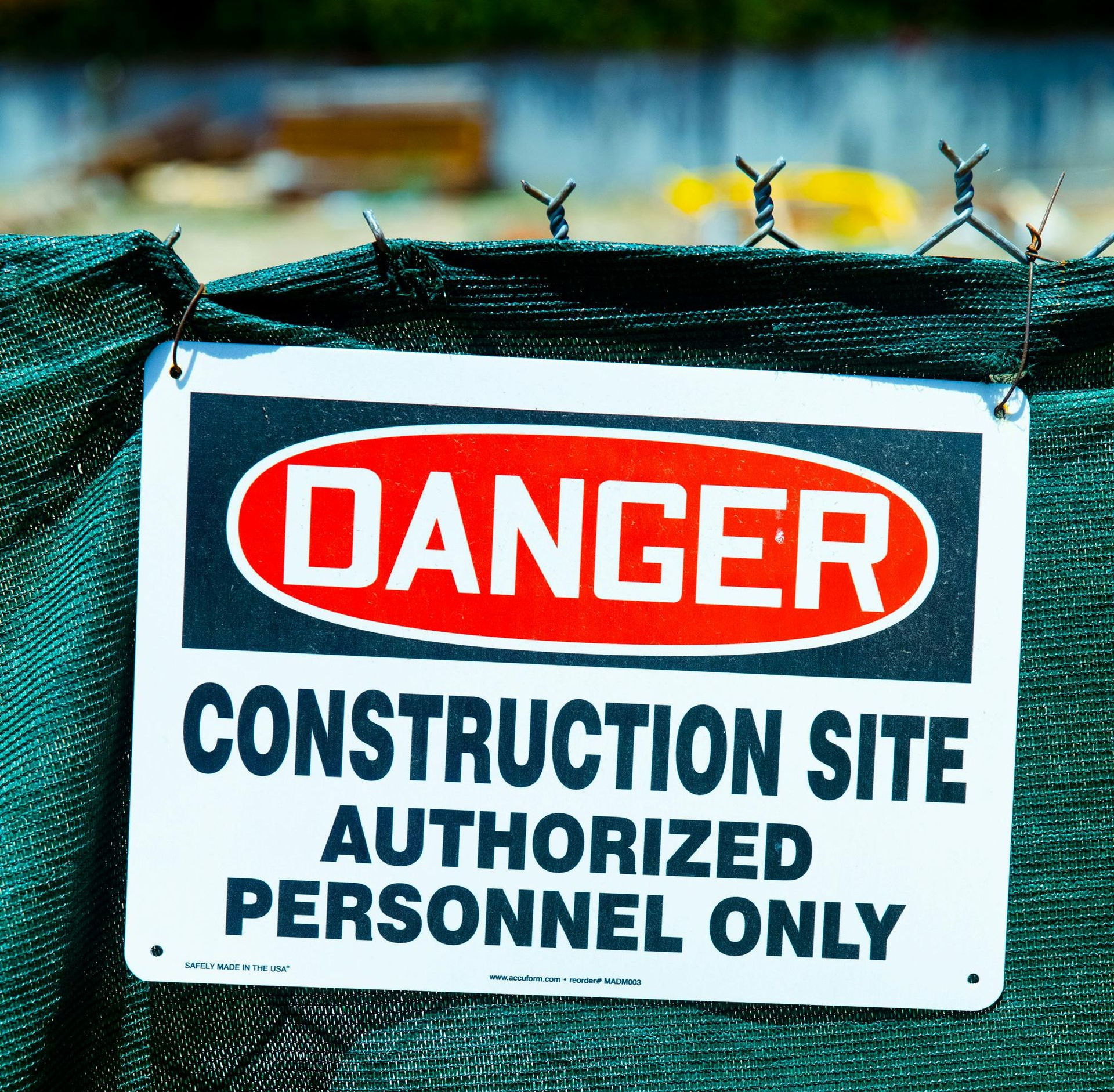 Danger sign on green fence: Construction site, authorized personnel only