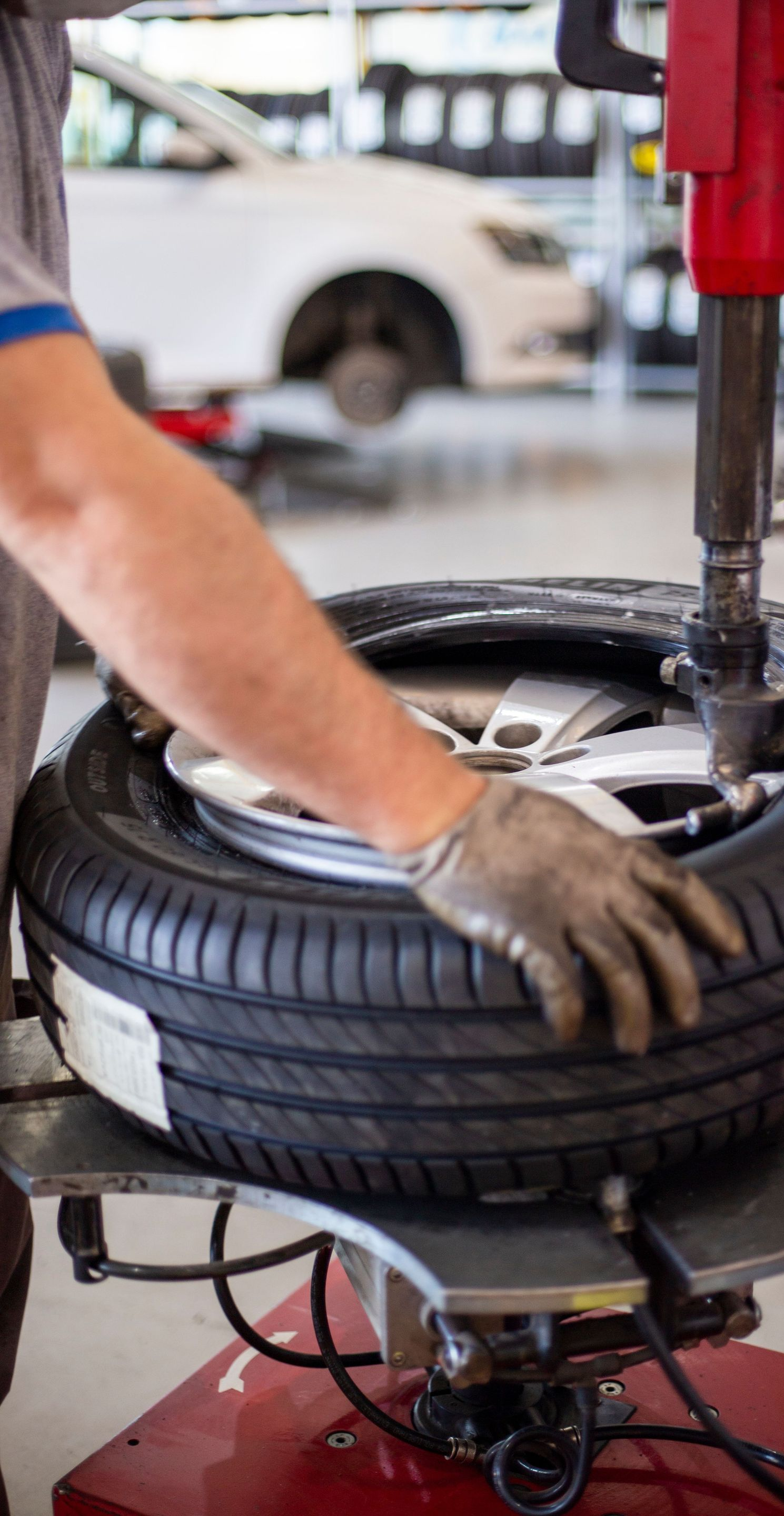 Mechanic using a tire-changing machine to mount a tire in an auto shop