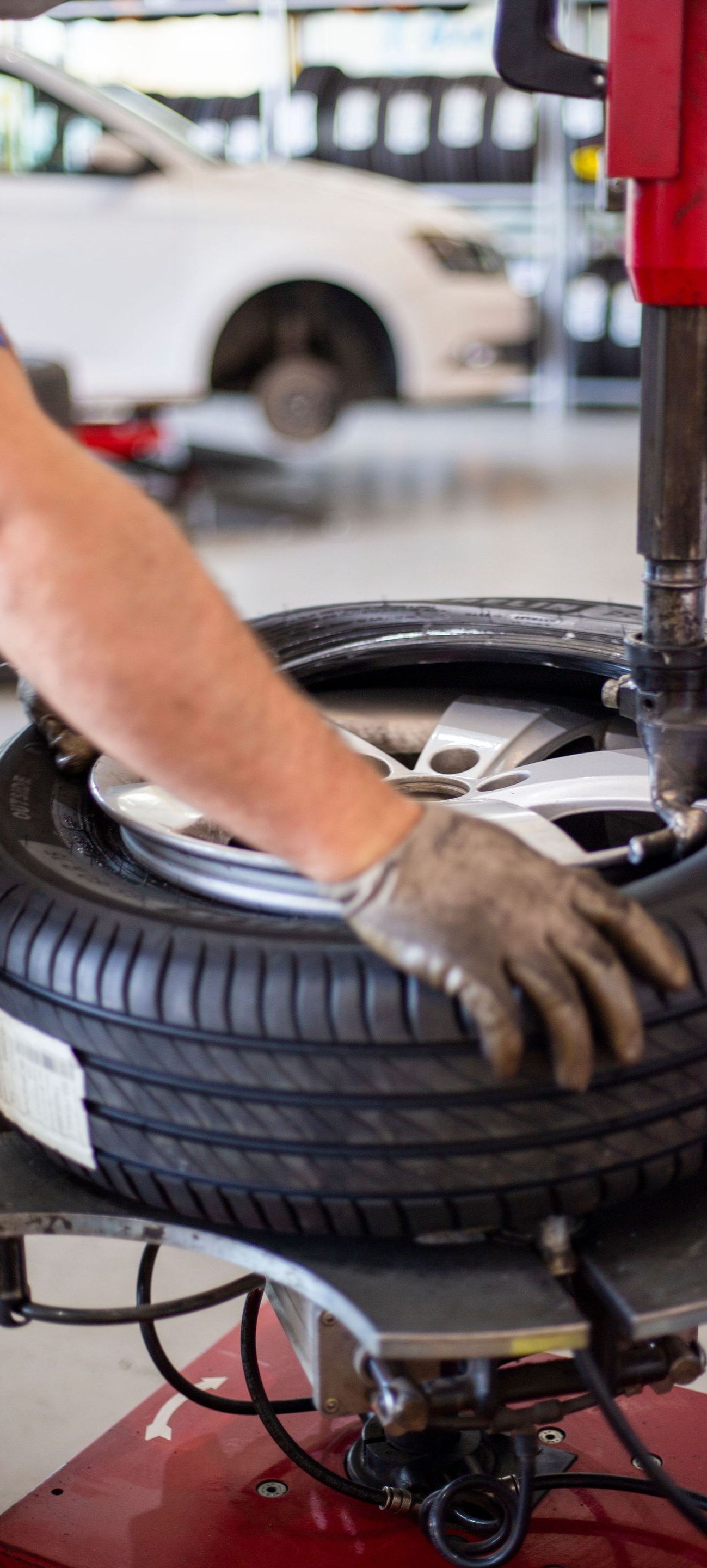 Mechanic using a tire-changing machine to mount a tire in an auto shop
