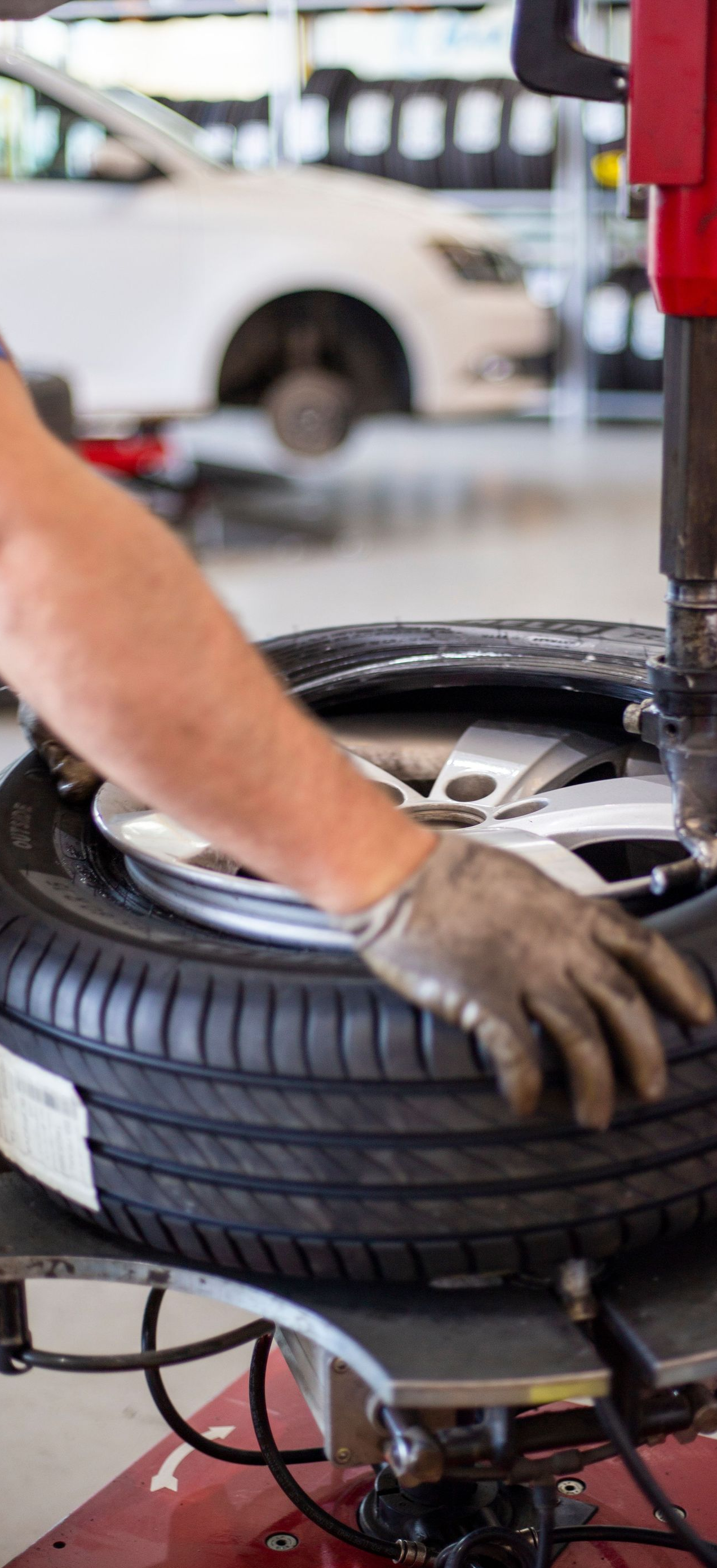 Mechanic using a tire-changing machine to mount a tire in an auto shop