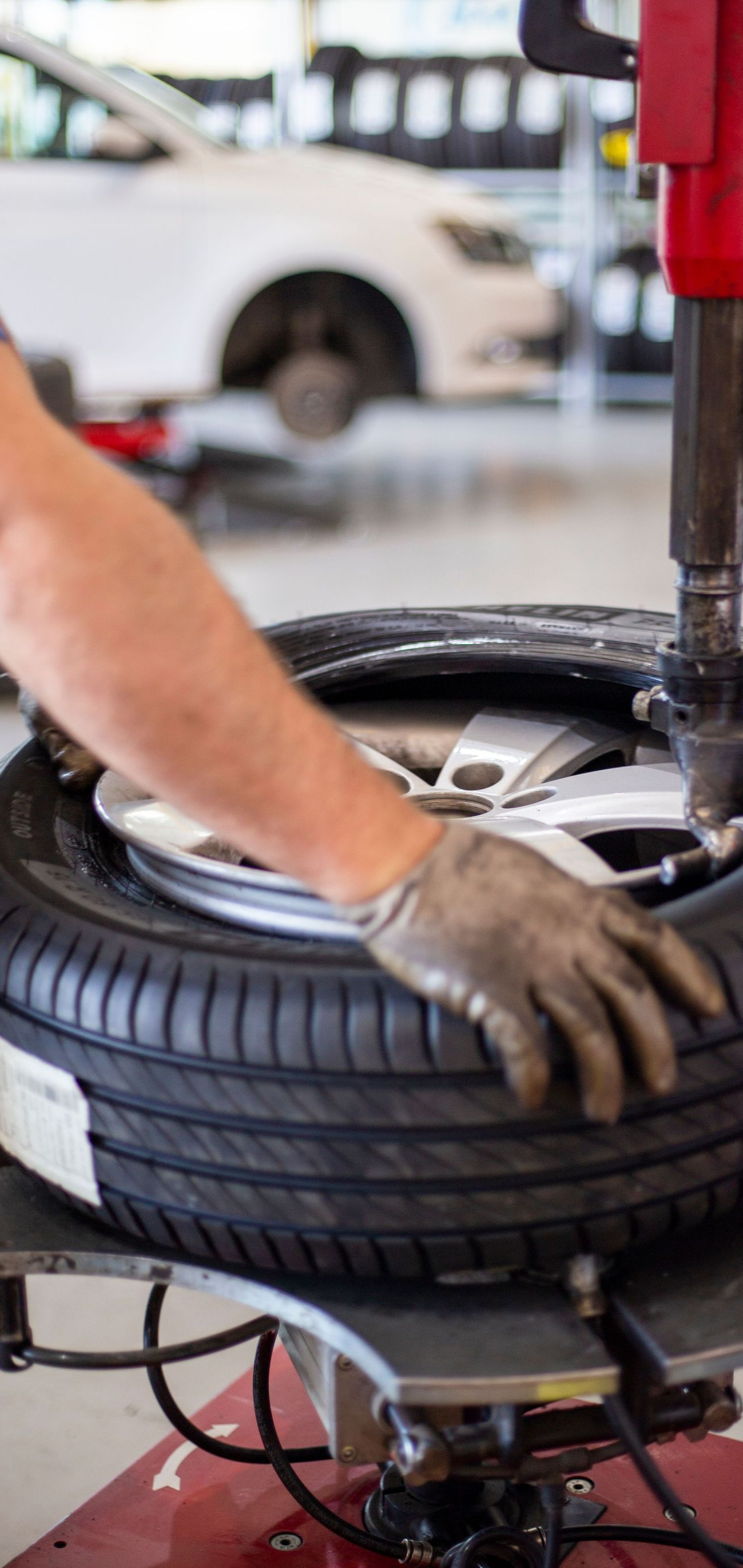 Mechanic using a tire-changing machine to mount a tire in an auto shop