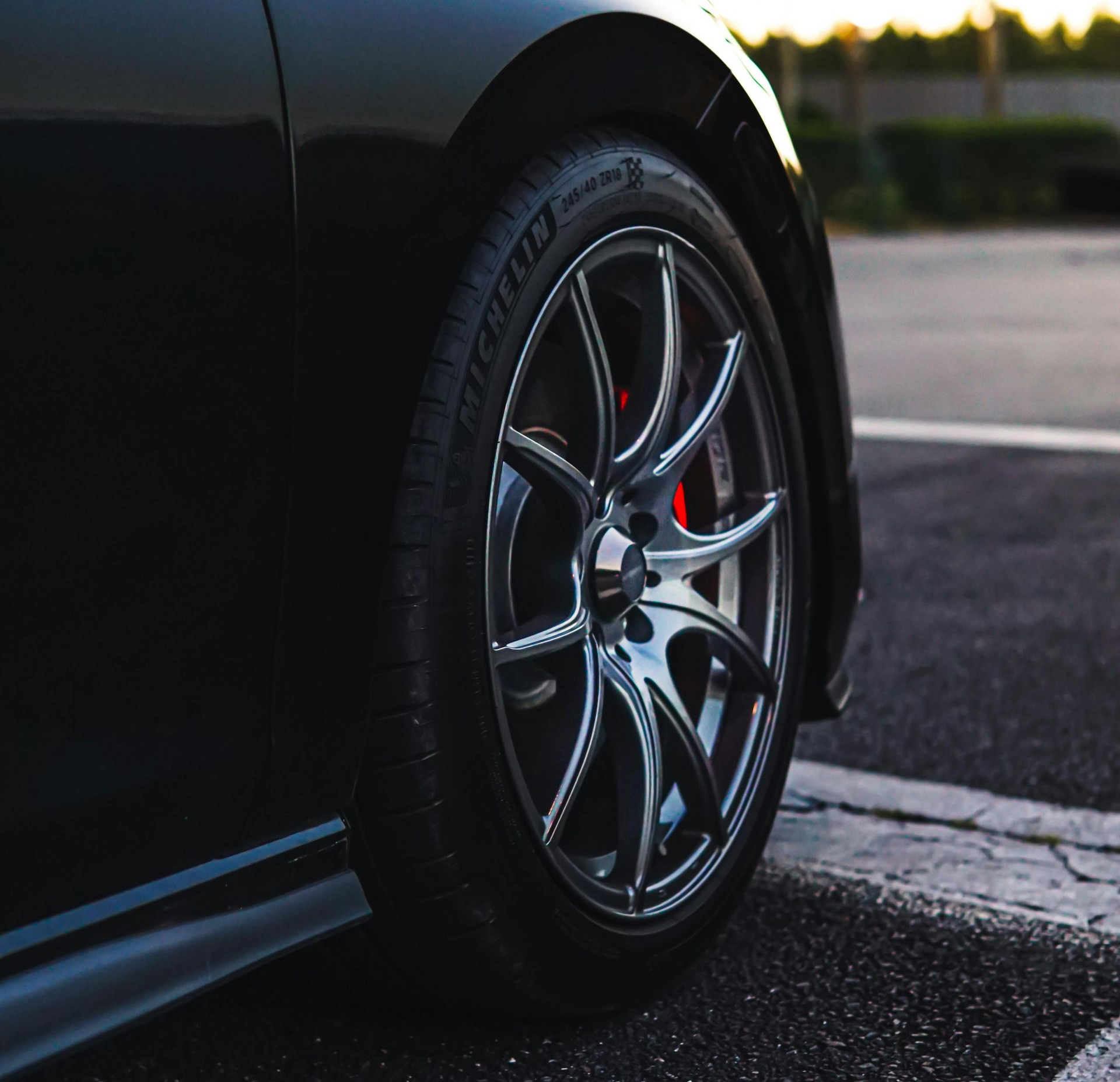 Black VW GTI car with red brake calipers, side view, parked near a building.