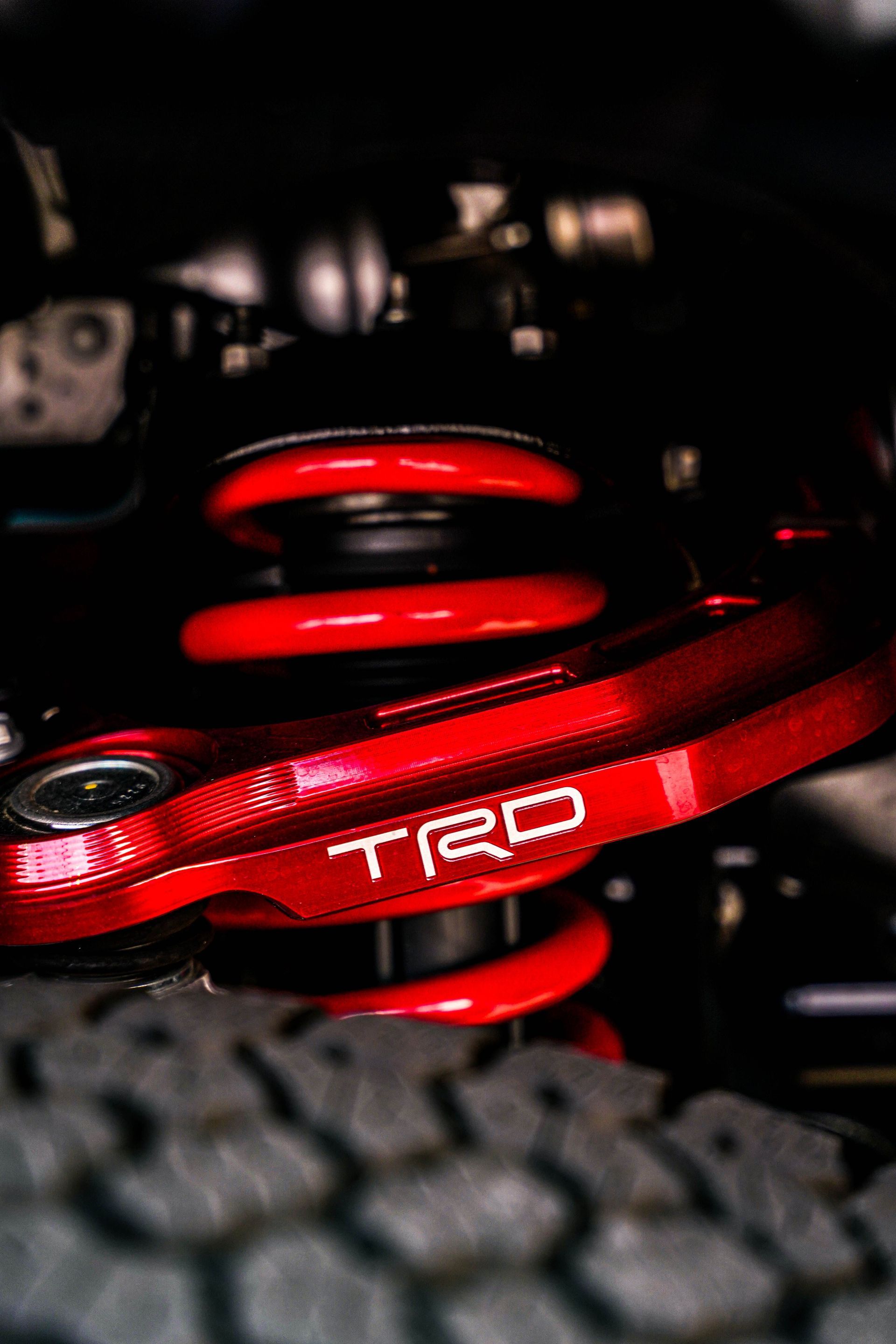 Red TRD suspension spring and component in a car engine bay