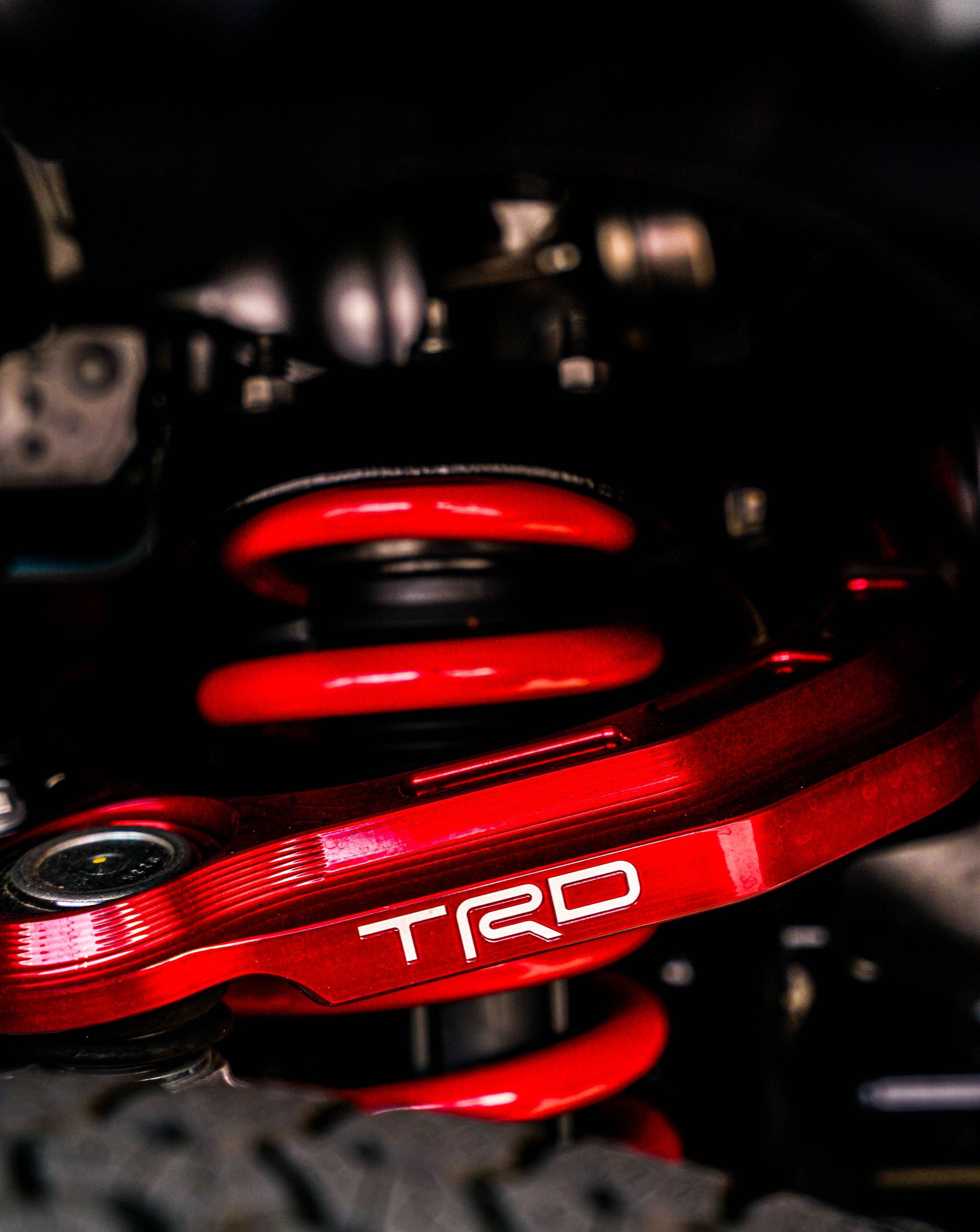 Red TRD suspension spring and component in a car engine bay