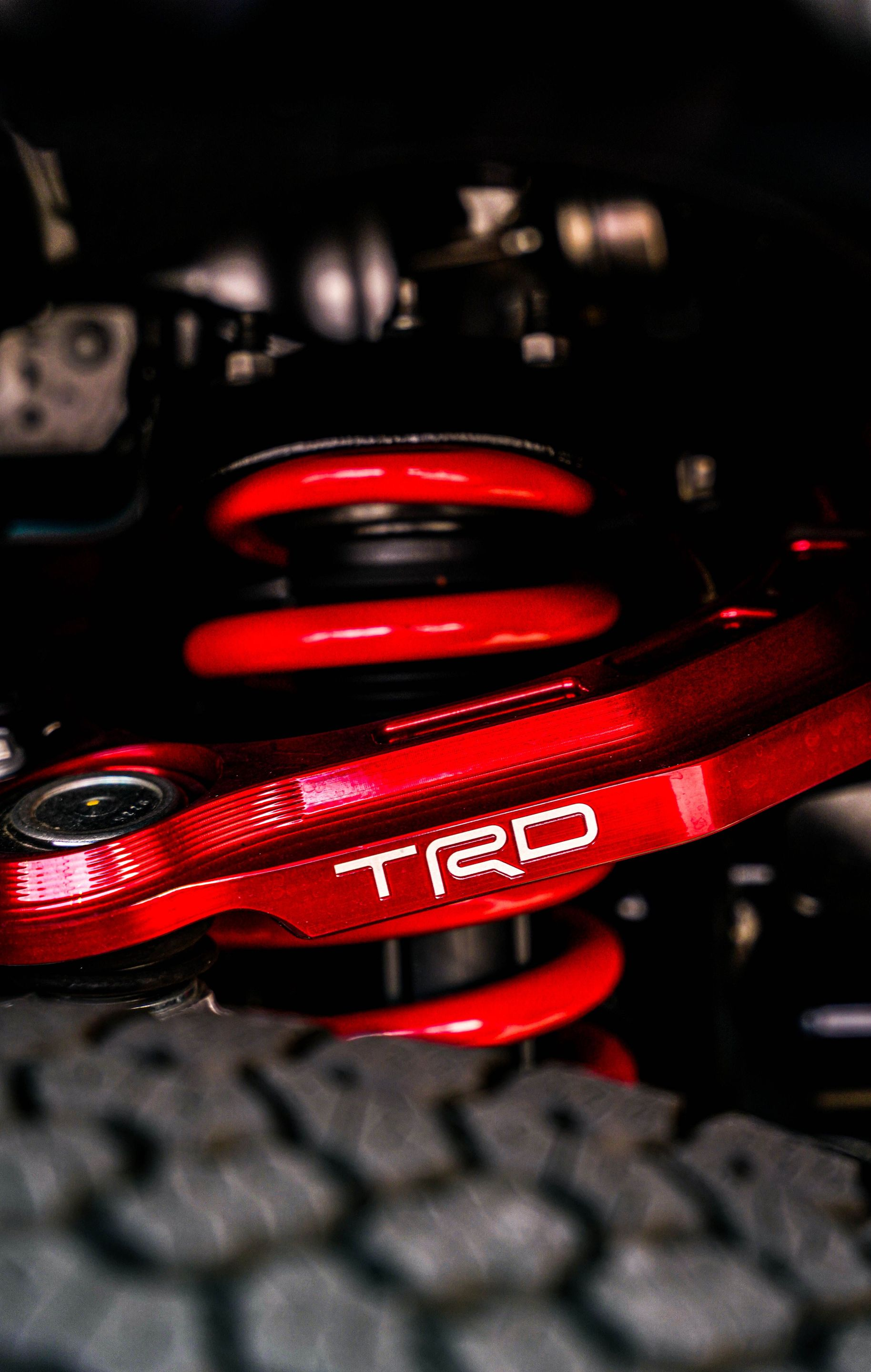 Red TRD suspension spring and component in a car engine bay