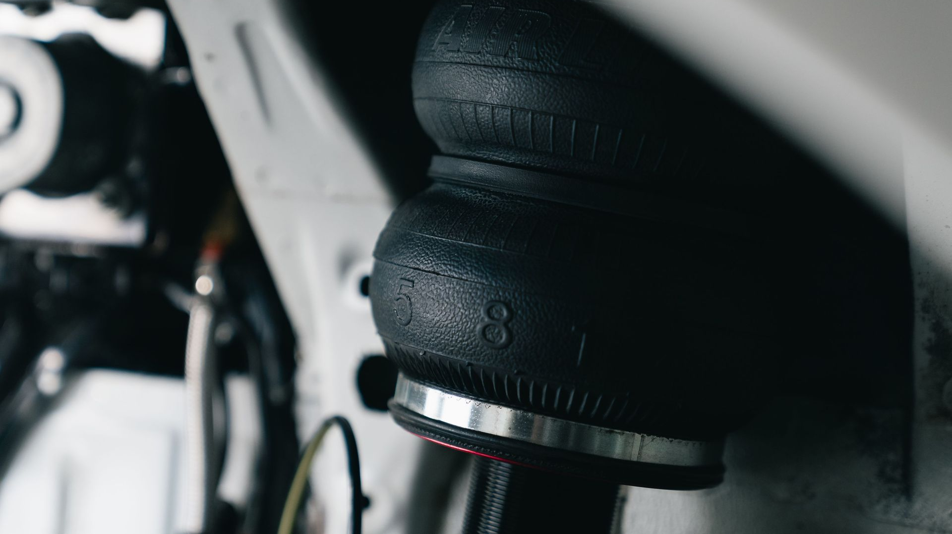 Close-up of a black gear shift boot and knob inside a vehicle, with a metallic trim ring