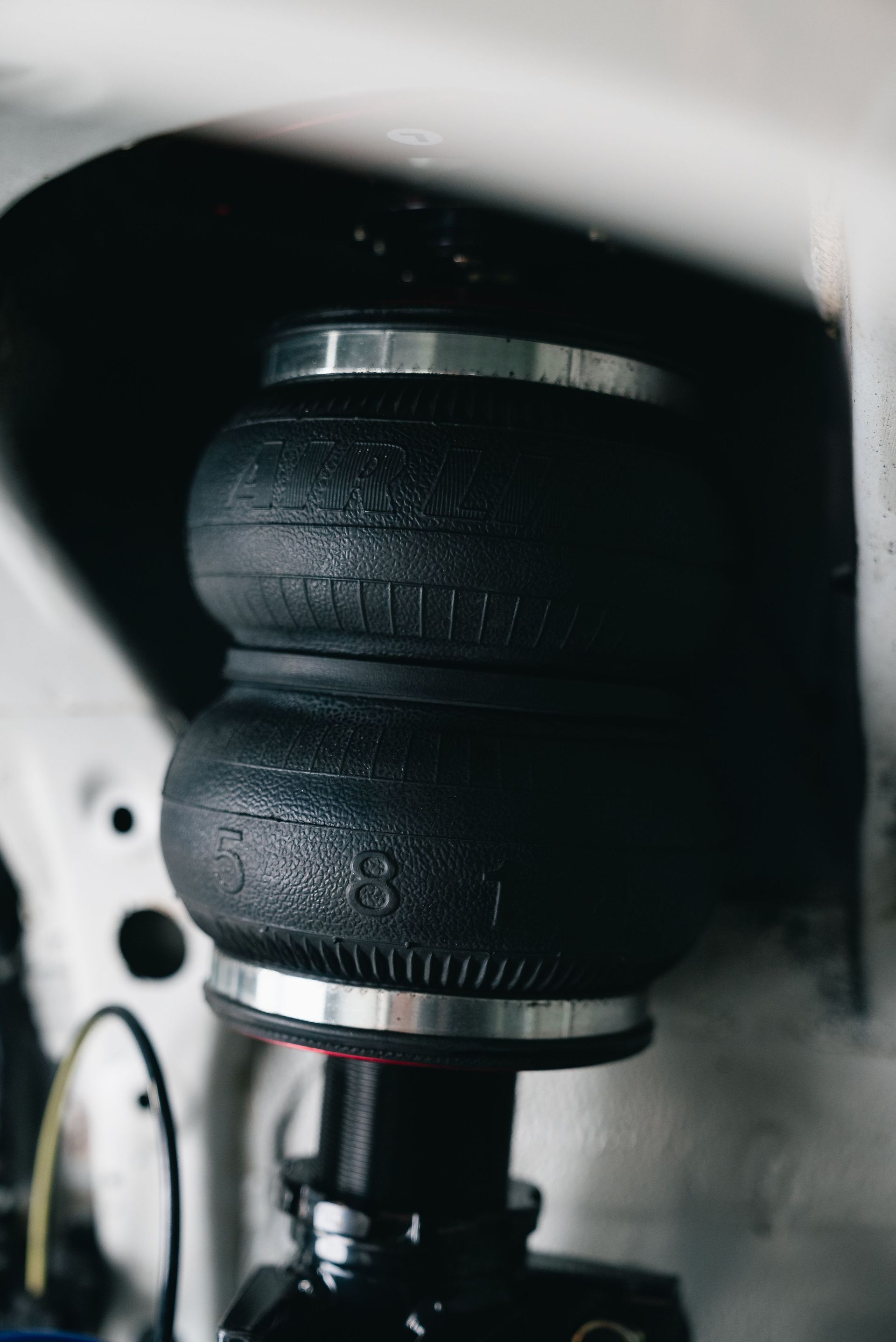 Close-up of a black rubber air spring in a vehicle suspension assembly