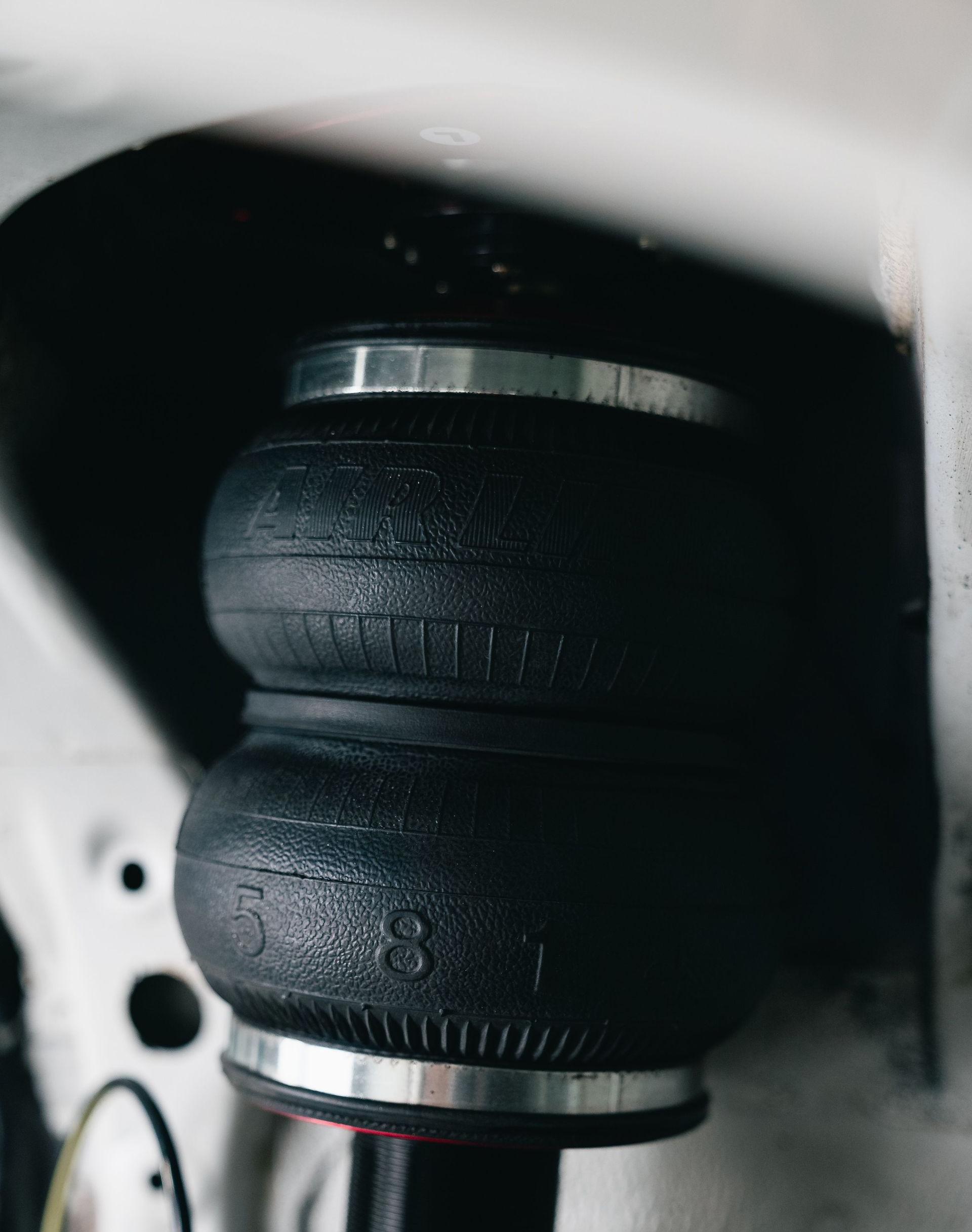 Close-up of a black rubber air spring in a vehicle suspension assembly