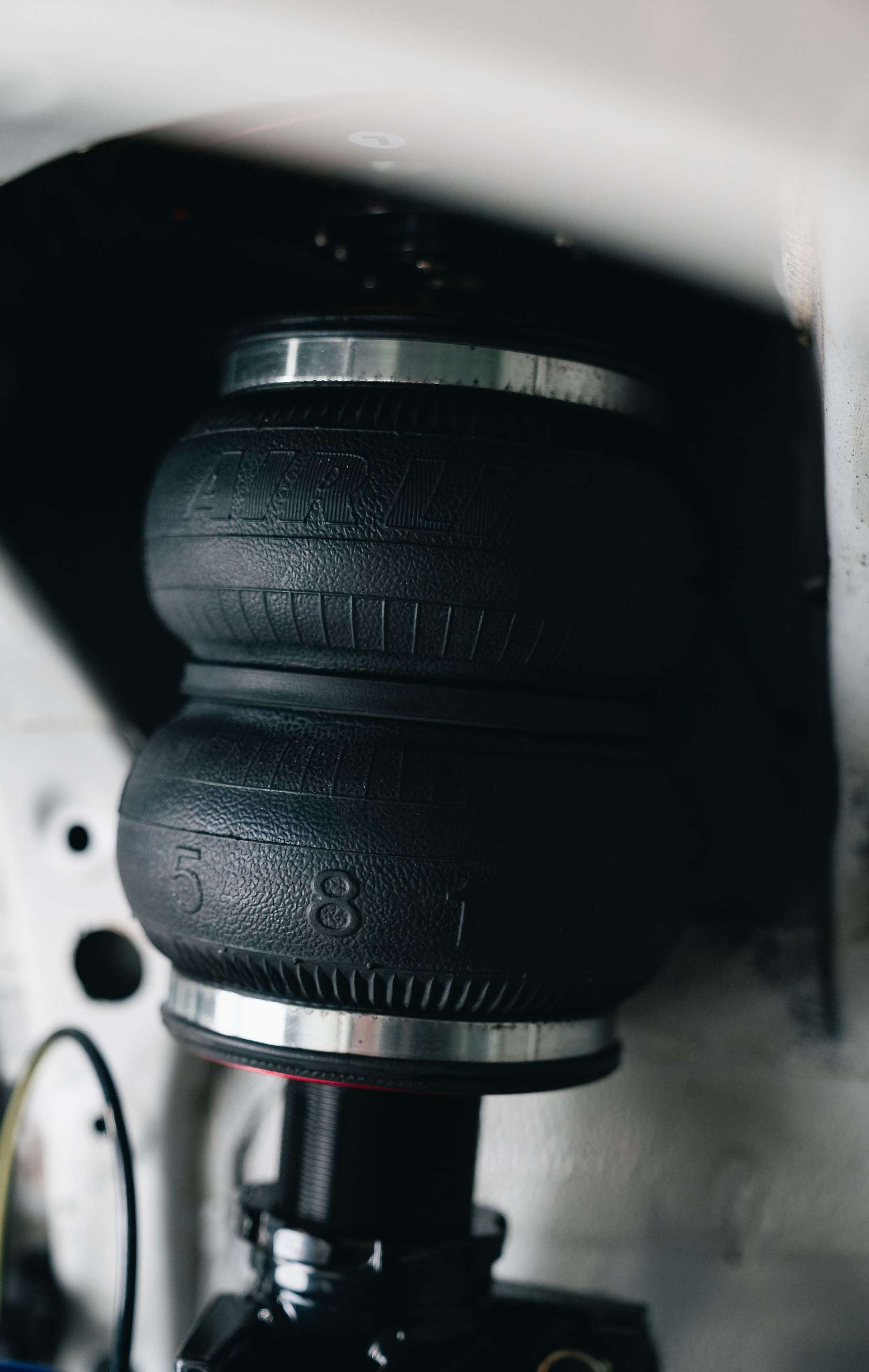 Close-up of a black rubber air spring in a vehicle suspension assembly