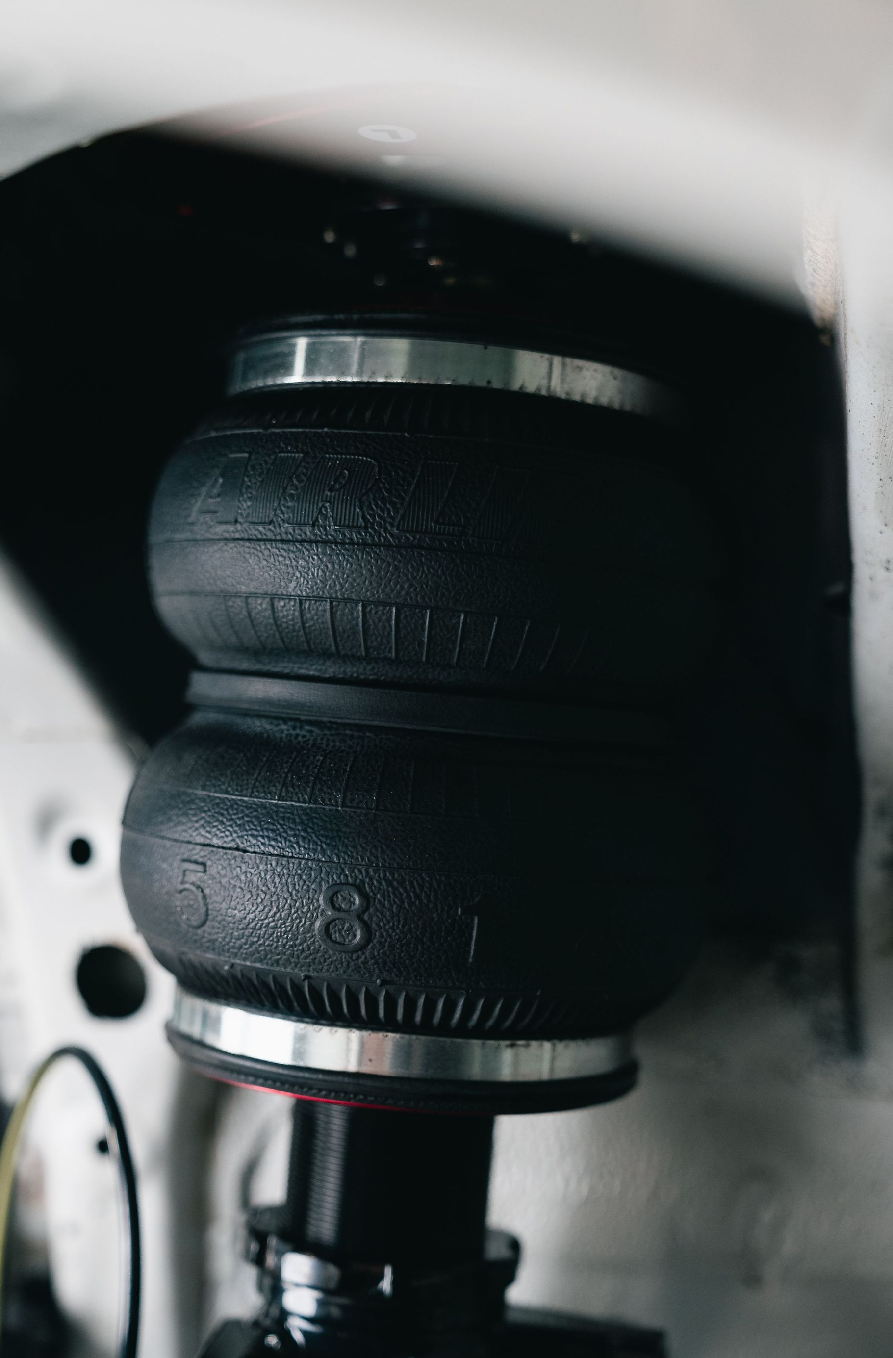 Close-up of a black rubber air spring in a vehicle suspension assembly
