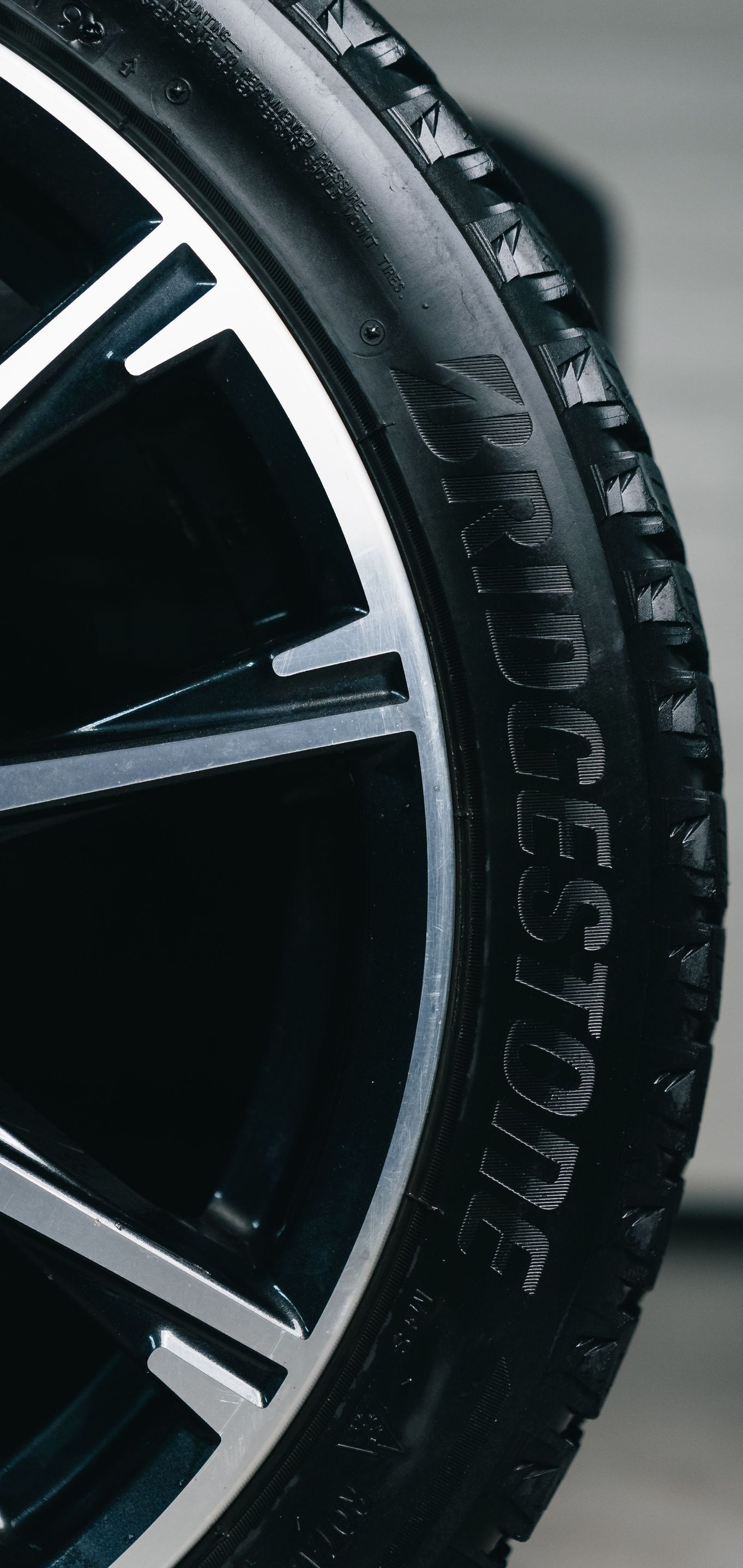 Close-up of a black car tire and silver alloy wheel rim