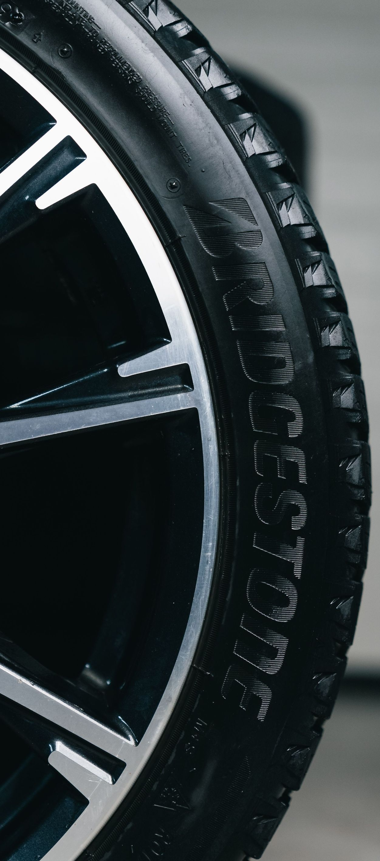 Close-up of a black car tire and silver alloy wheel rim