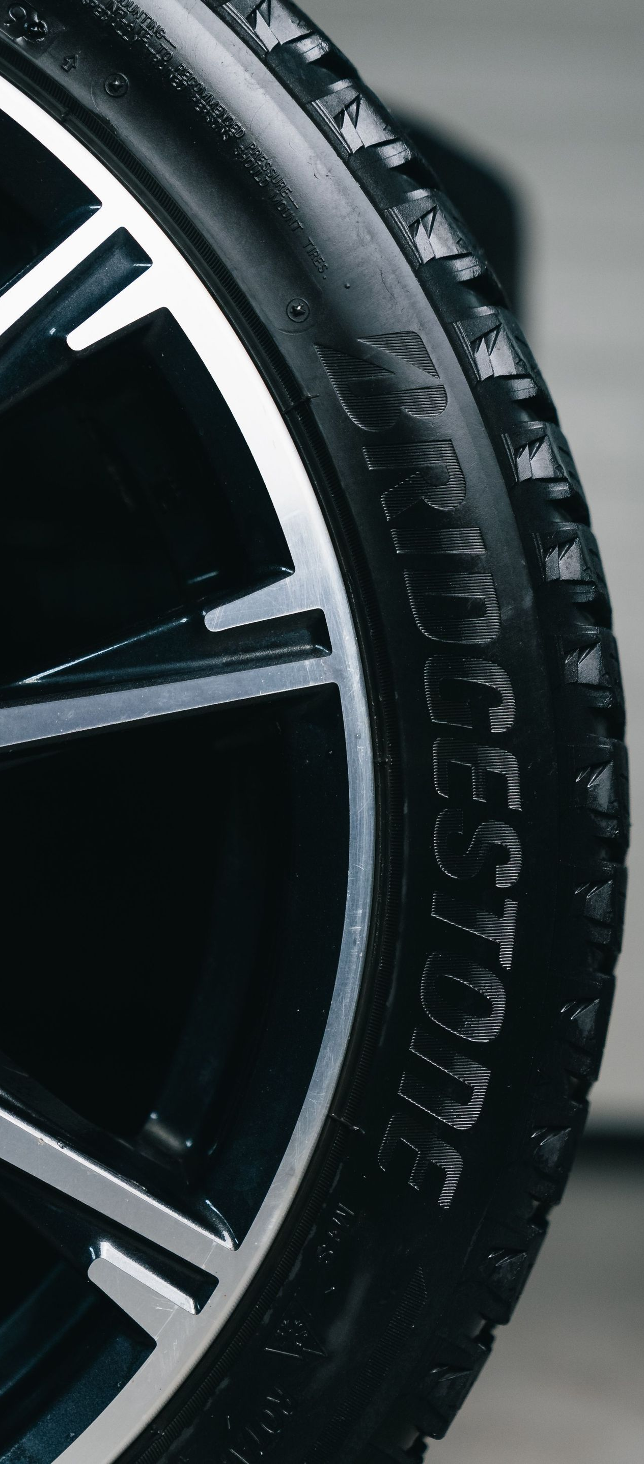 Close-up of a black car tire and silver alloy wheel rim