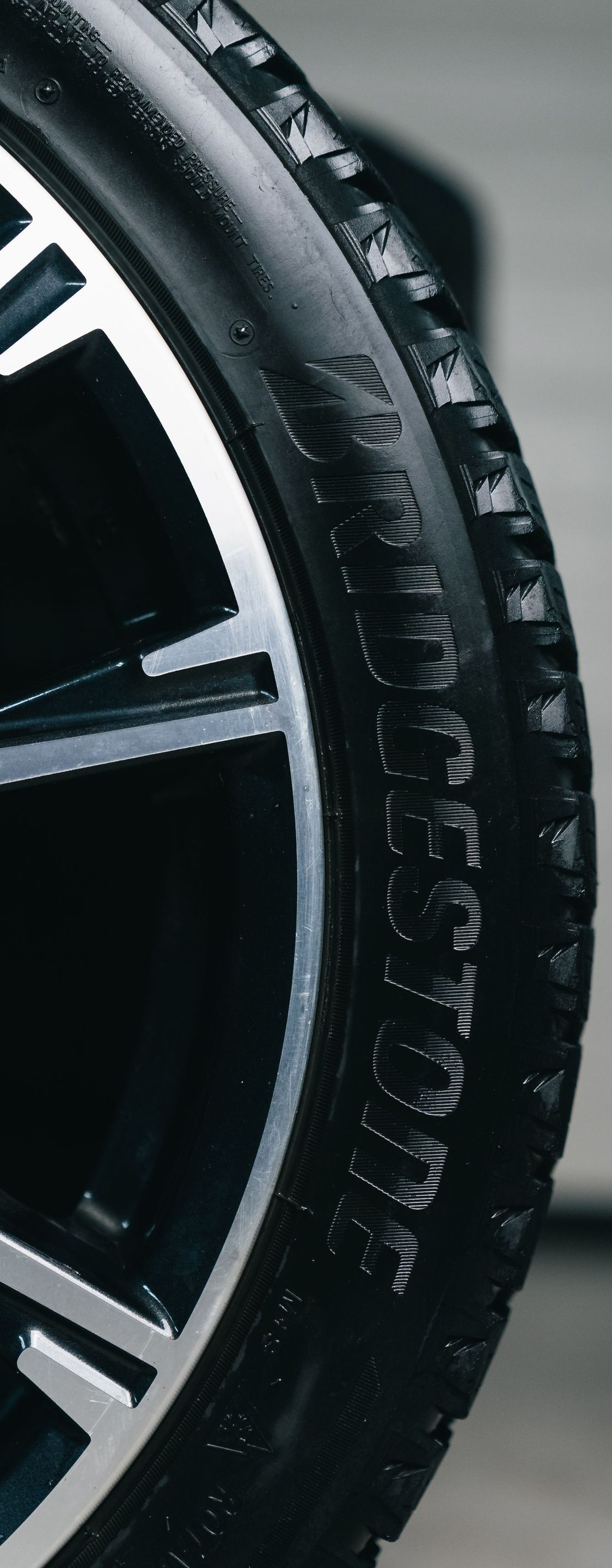 Close-up of a black car tire and silver alloy wheel rim