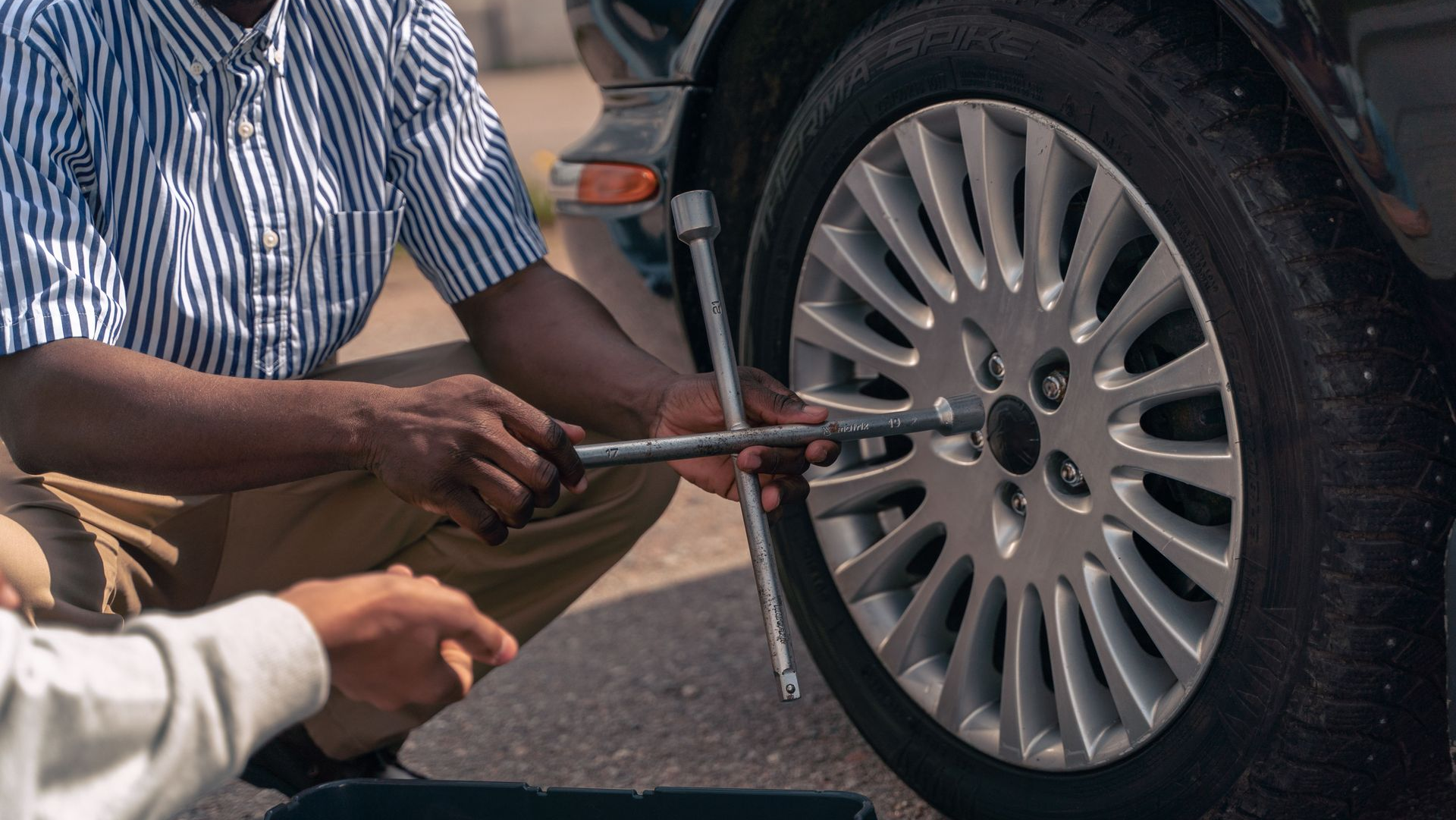 Mechanic tightening lug nuts on a car wheel with a wrench