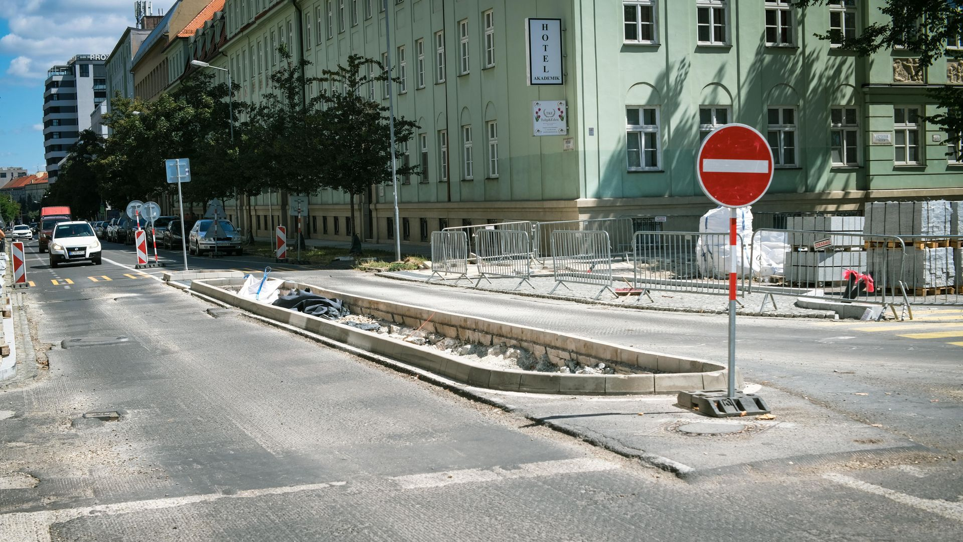 Street scene with a road construction zone featuring a central curb divider and a