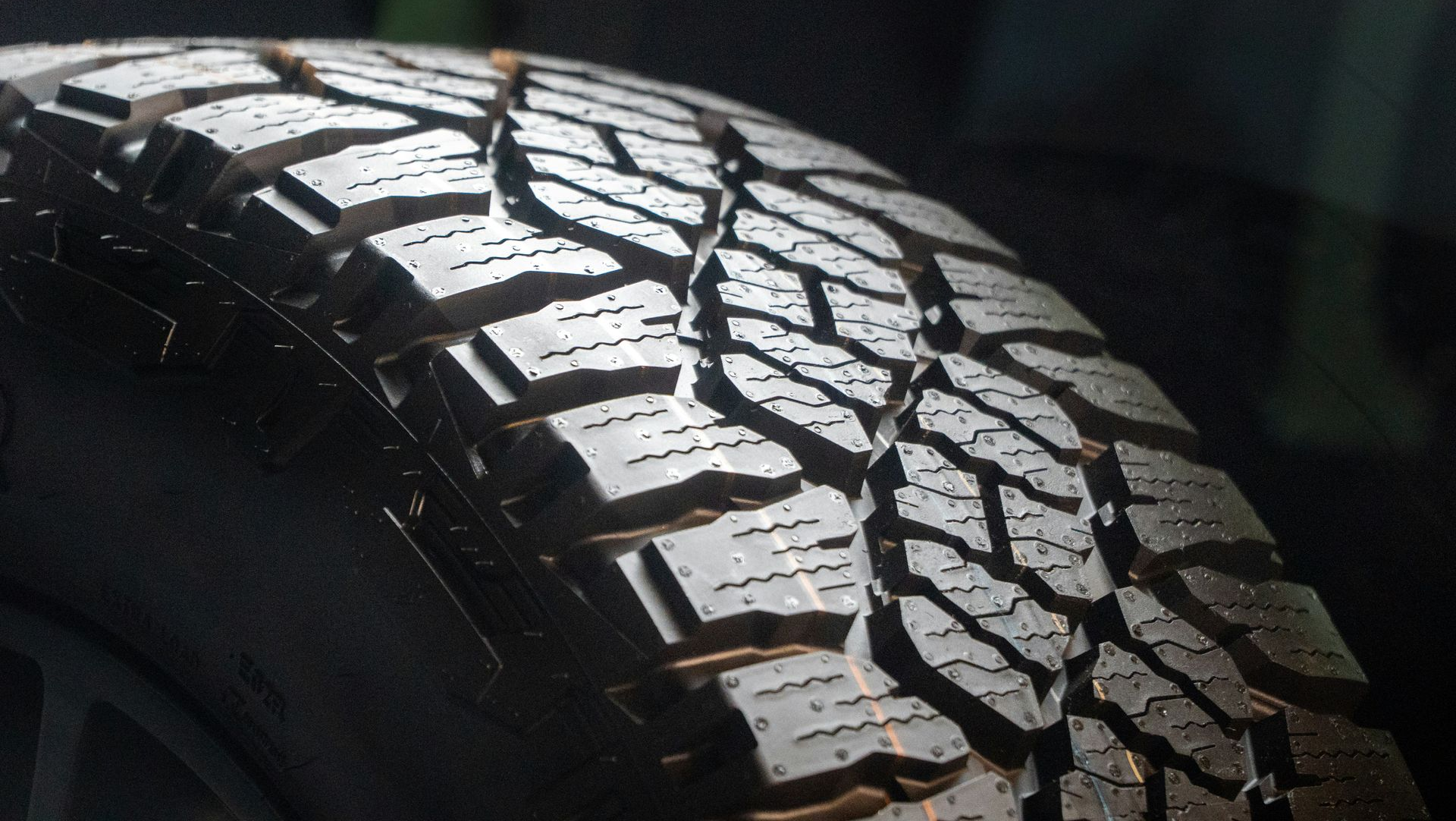 Close-up of a rugged black off-road tire with deep tread pattern