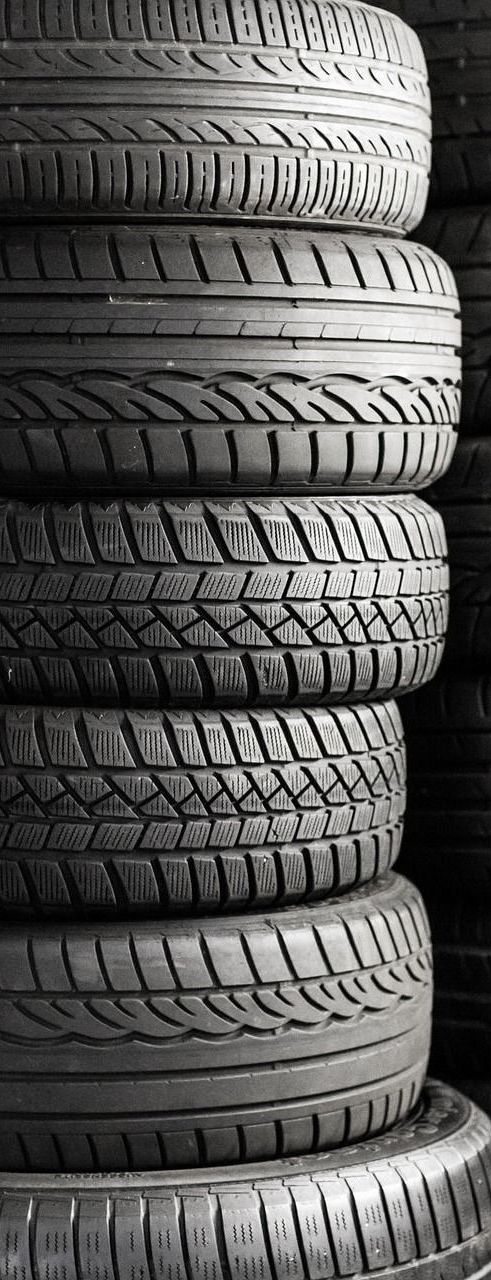 Stack of used tires in black and white.