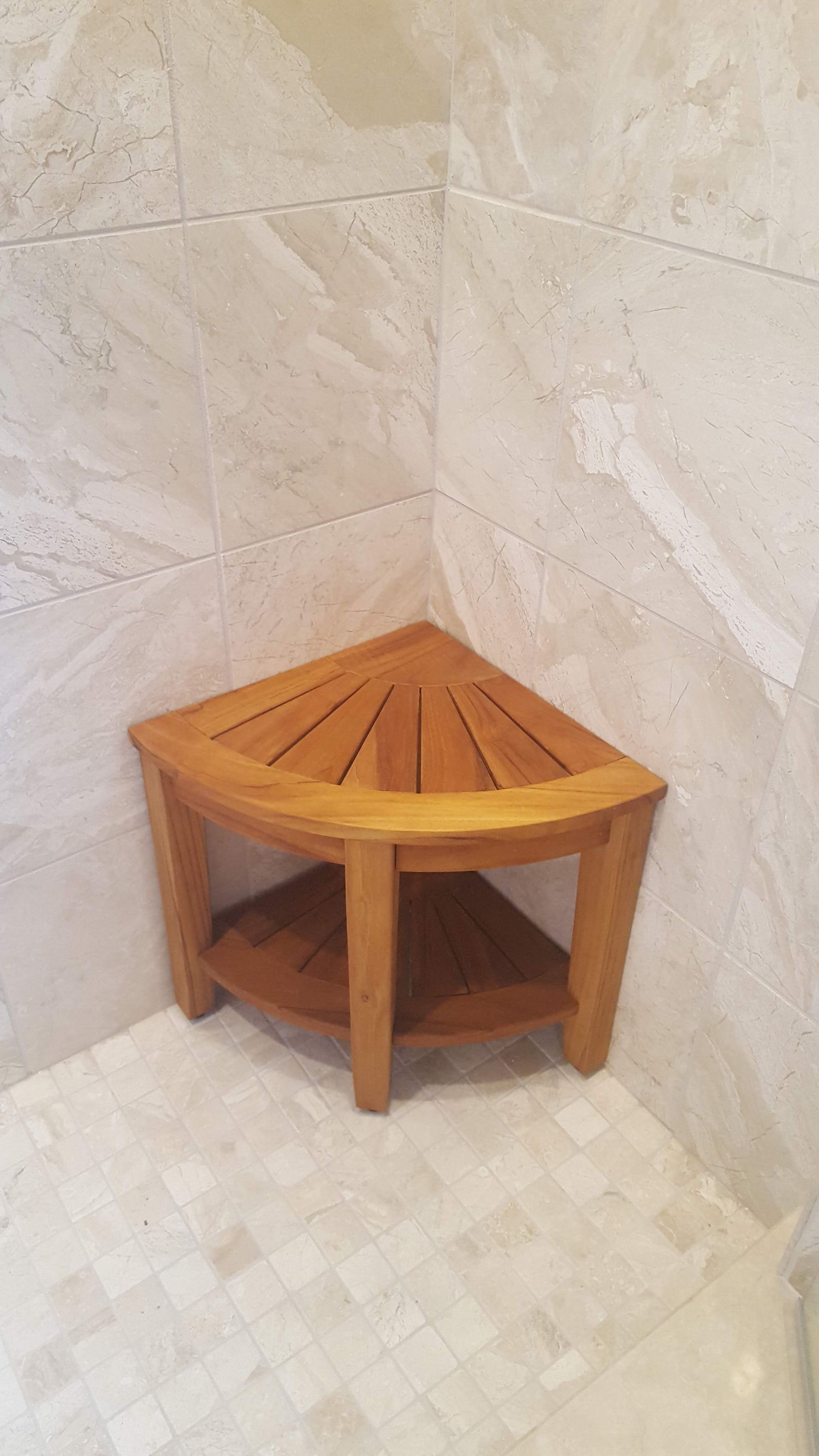 Wooden corner shower bench in a tiled bathroom