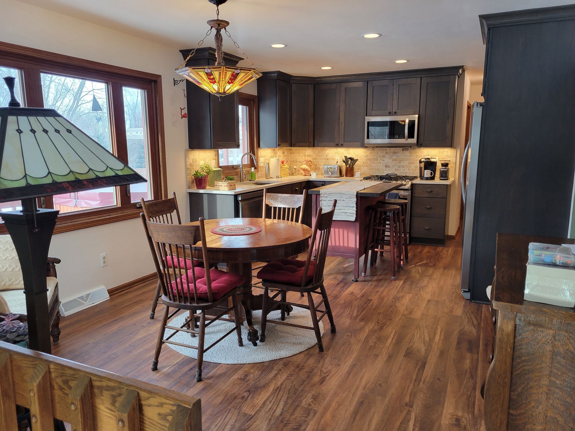 Cozy kitchen and dining area with dark wood cabinets, round table, and warm lighting