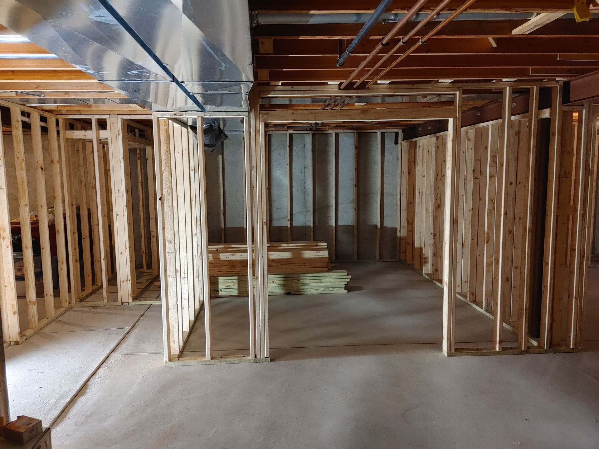 Framed basement interior with exposed wooden studs and unfinished concrete floor