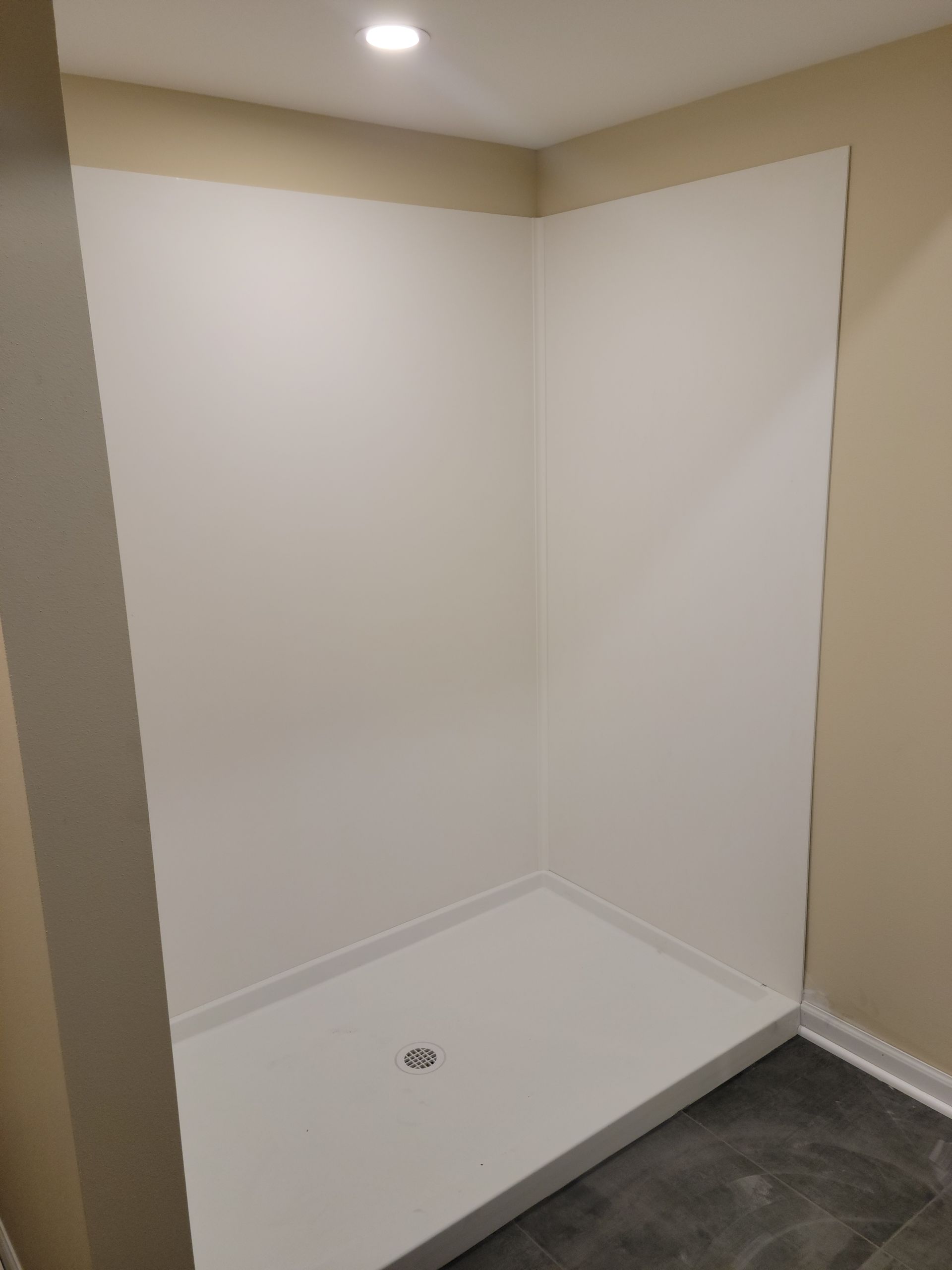 Empty white closet nook with a hanging rod and dark carpet floor