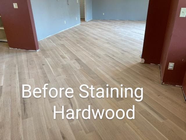 Empty room with light hardwood floor and the text “Before Staining Hardwood” overlaid.
