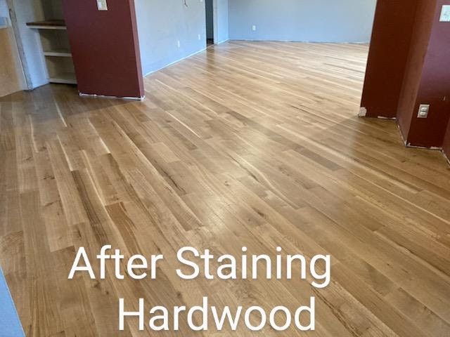 Stained hardwood flooring in a vacant room, showing a warm wood finish