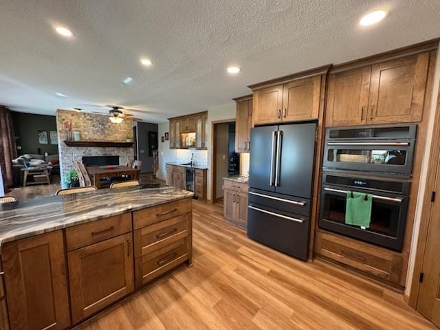 Modern kitchen with wood cabinets, island, stainless appliances, and warm hardwood floors