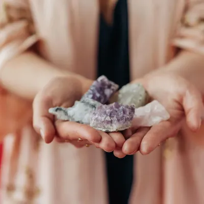 benessere e salute 8 elementi pianezzo una donna tiene in mano un cristallo di pietre viola e bianche .