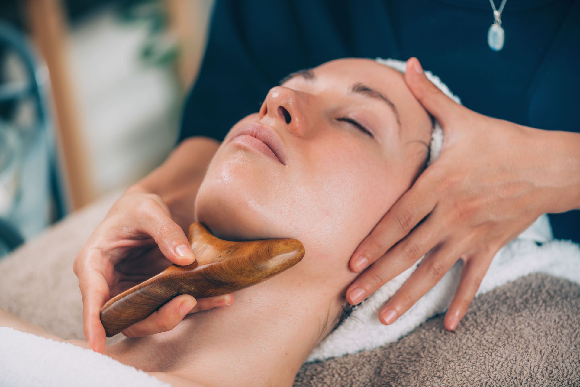 una donna sta ricevendo un massaggio al viso maderoterapia in un salone di bellezza .