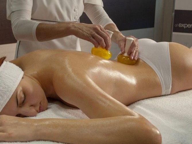 Una donna è sdraiata su un lettino da massaggio mentre riceve un massaggio.