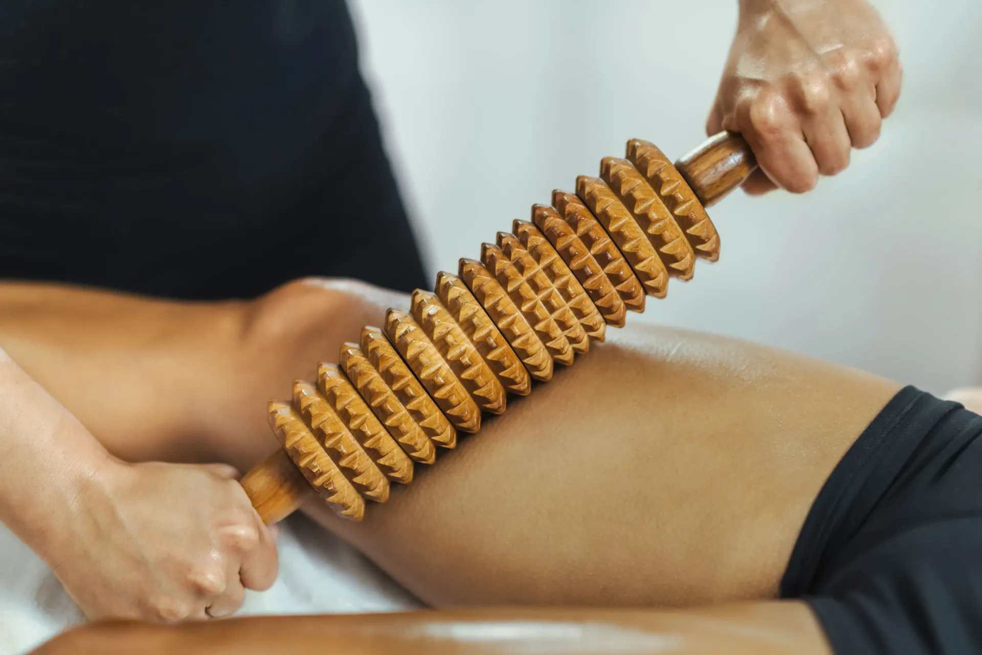 una donna sta ricevendo un massaggio con un rullo di legno .