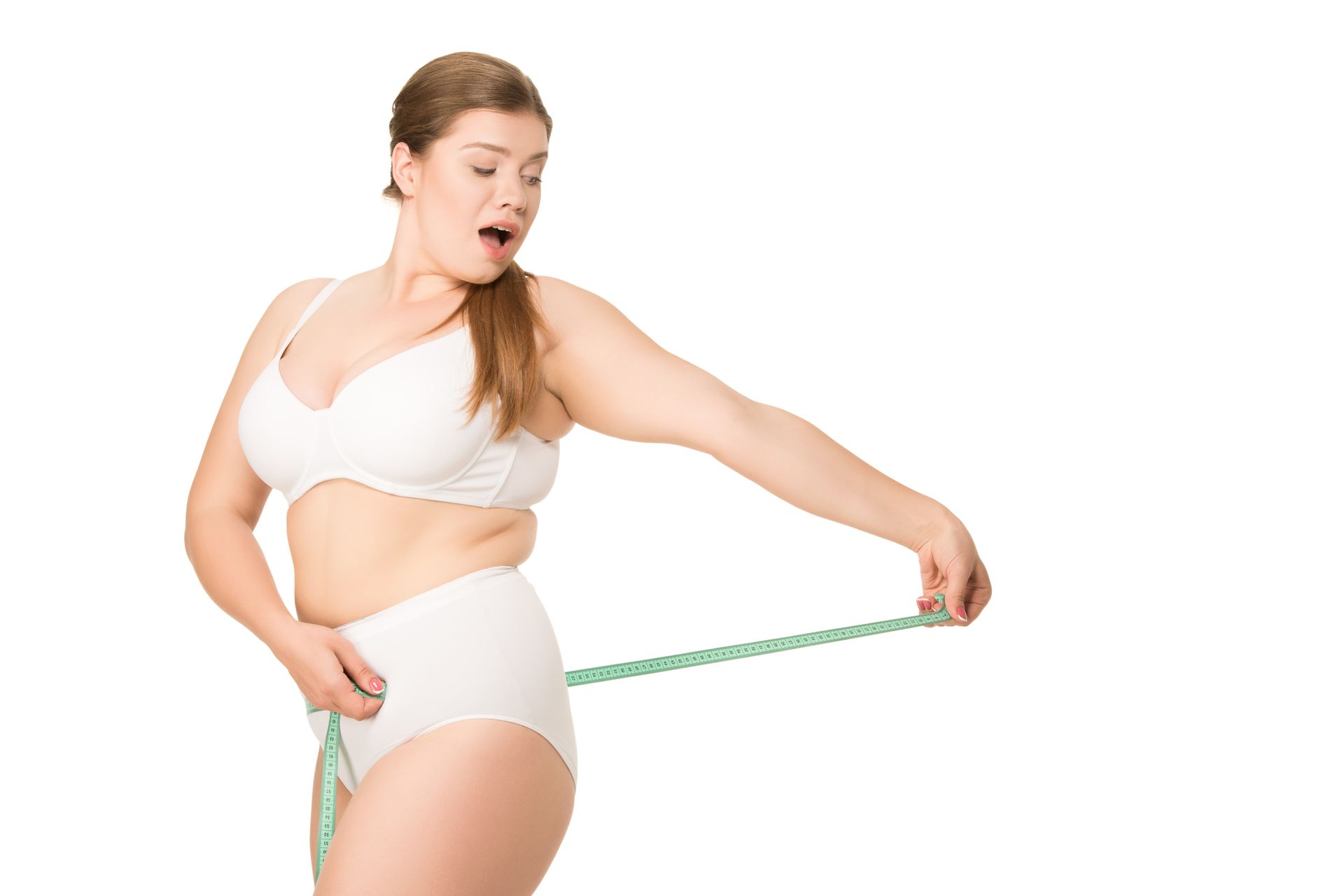 A woman in underwear is measuring her waist with a tape measure.