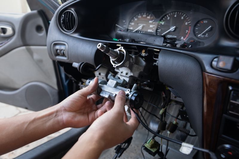 Hands removing a car dashboard stereo unit, with exposed wiring and gauges visible.