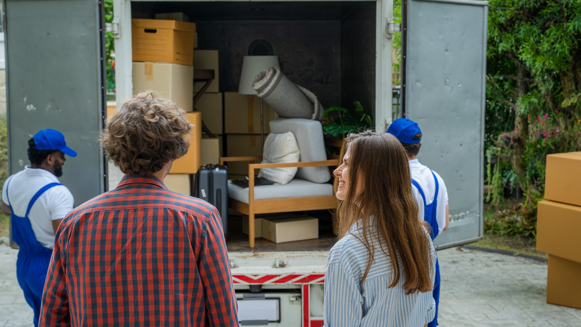 A man and a woman are standing in front of a moving truck.
