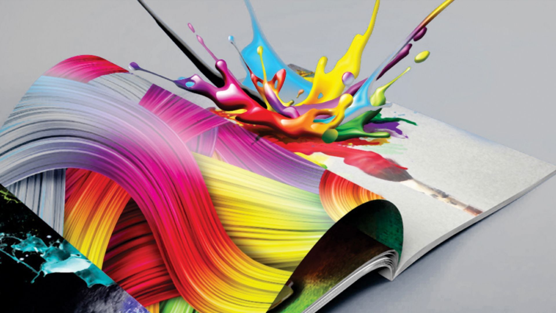 Colorful paint splash over an open book, with vivid pink, yellow, blue, and orange waves
