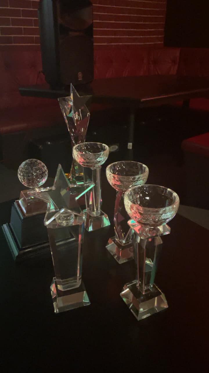 A group of glass trophies are sitting on a table.