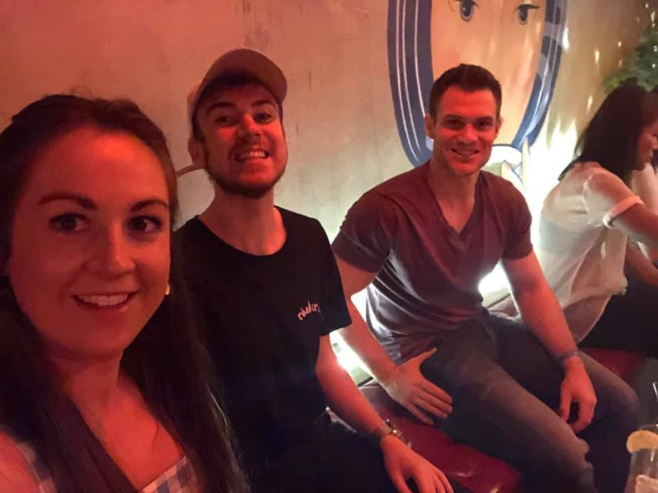A group of people are posing for a picture in a dark room.