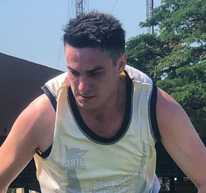 A man wearing a yellow tank top with the word bike on it