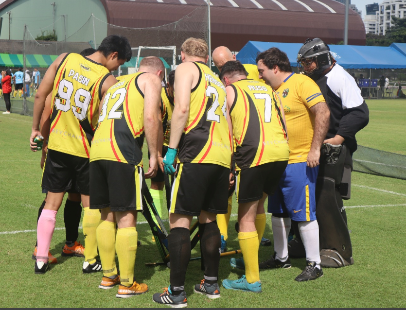 A group of soccer players are huddled together and one has the number 7 on his back