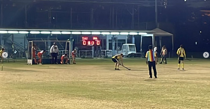 A group of people are playing a game of soccer on a field at night.