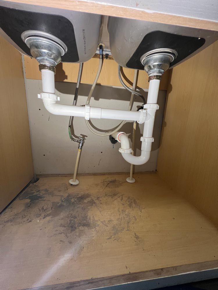 A kitchen sink with two sinks underneath it.