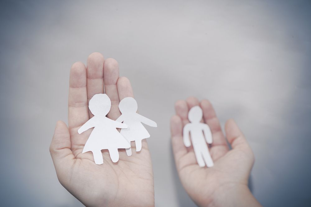 hands holding paper dolls showing separation from divorce